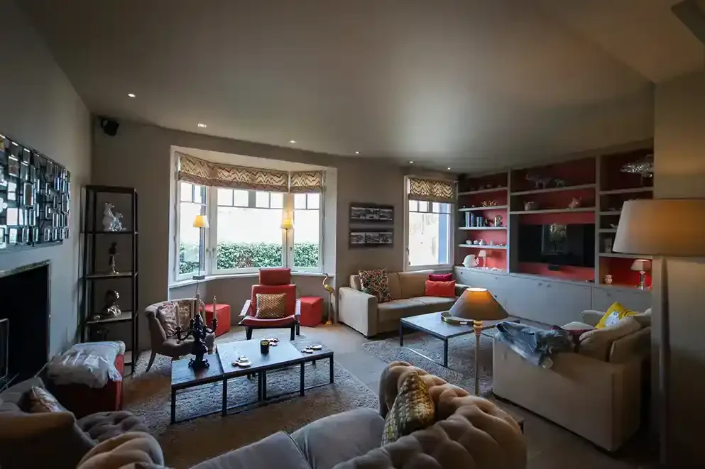 villa-chanteclair-deux-salons-deauville Vue d’ensemble des deux salons de la Villa Chanteclair à Deauville, combinant espace convivial avec canapés et cheminée