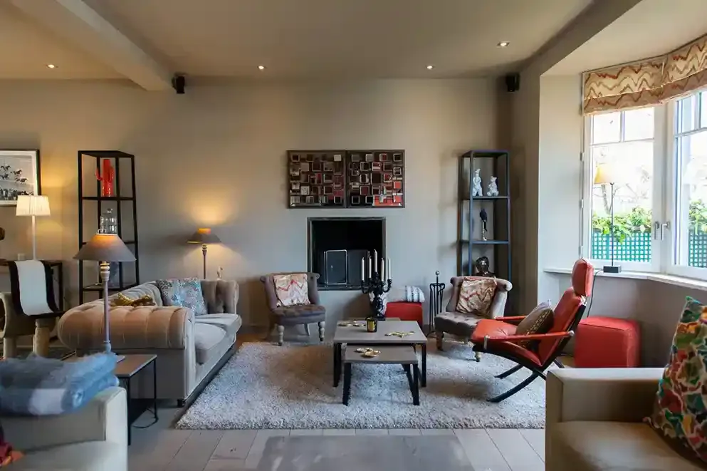 villa-chanteclair-salon-cheminee-canape Salon chaleureux de la Villa Chanteclair à Deauville avec cheminée et canapé confortable