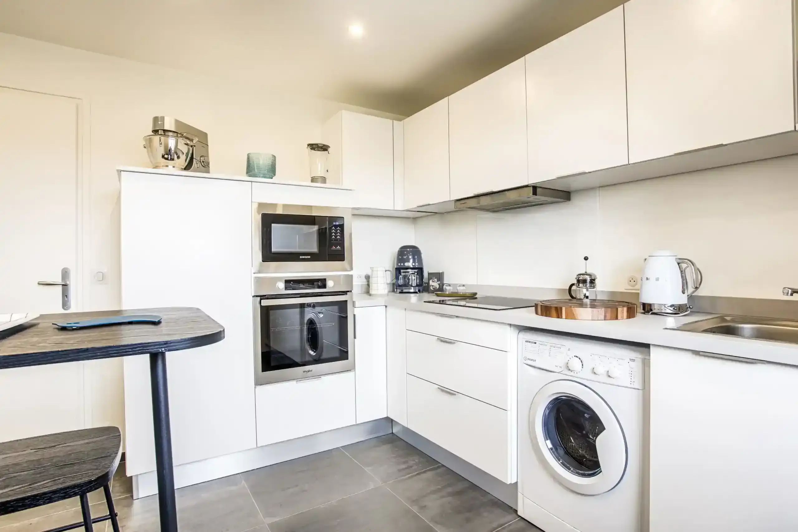 Appartement-ciel-mer-cuisine-ilot-haut-de-gamme Cuisine équipée avec électroménager, four et espace repas dans l’appartement Ciel et Mer à Deauville