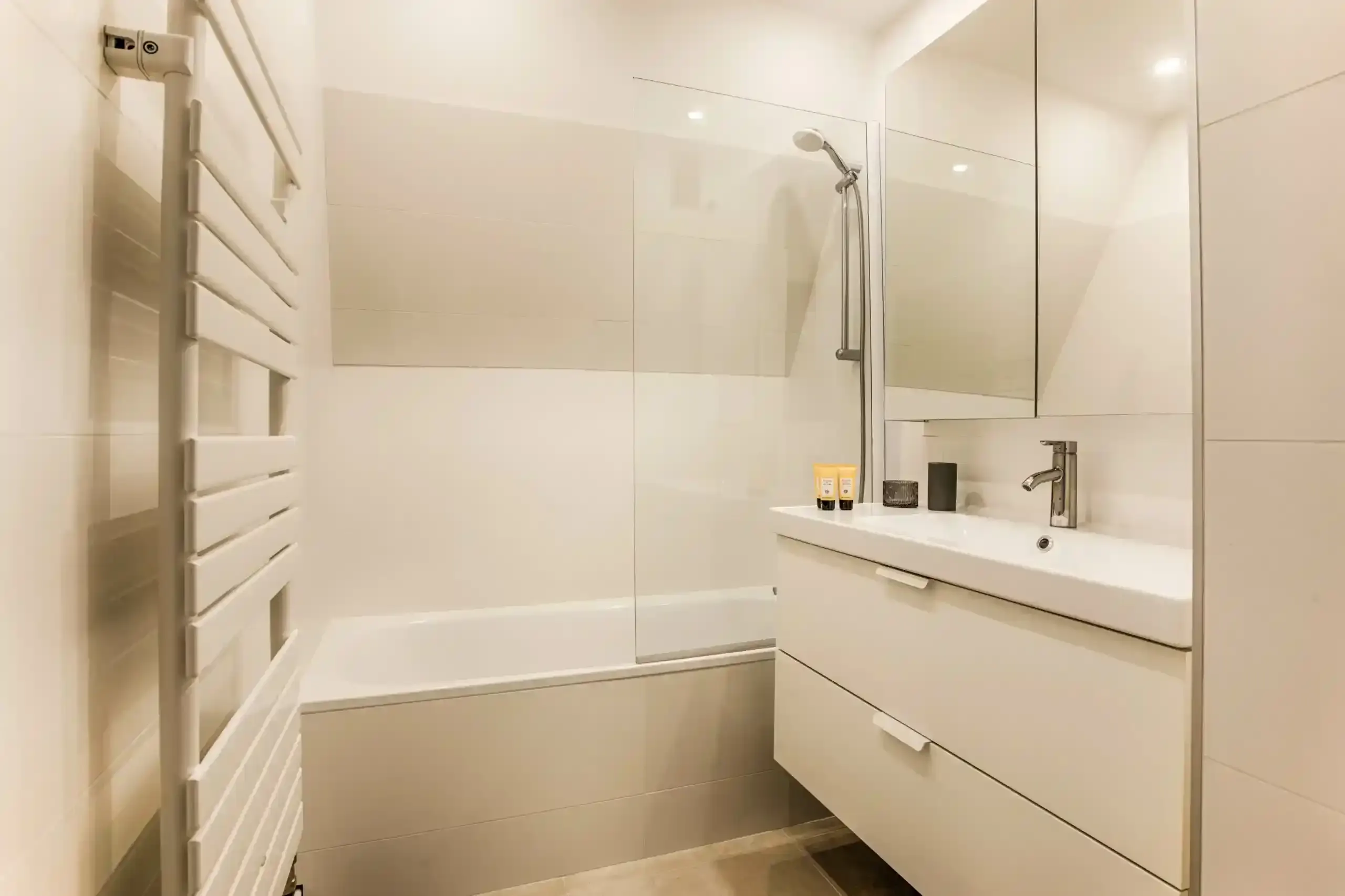 Appartement-ciel-mer-salle-de-bain-baignoire-douche Salle de bain moderne avec baignoire, douche et meuble vasque dans l’appartement Ciel et Mer