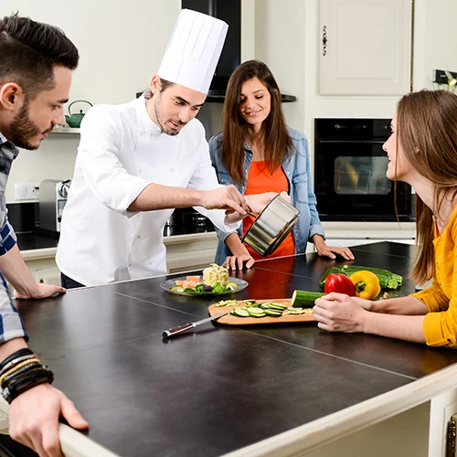 Prestation de cuisinier haut de gamme à domicile Cuisinier à domicile préparant un repas raffiné pour une famille