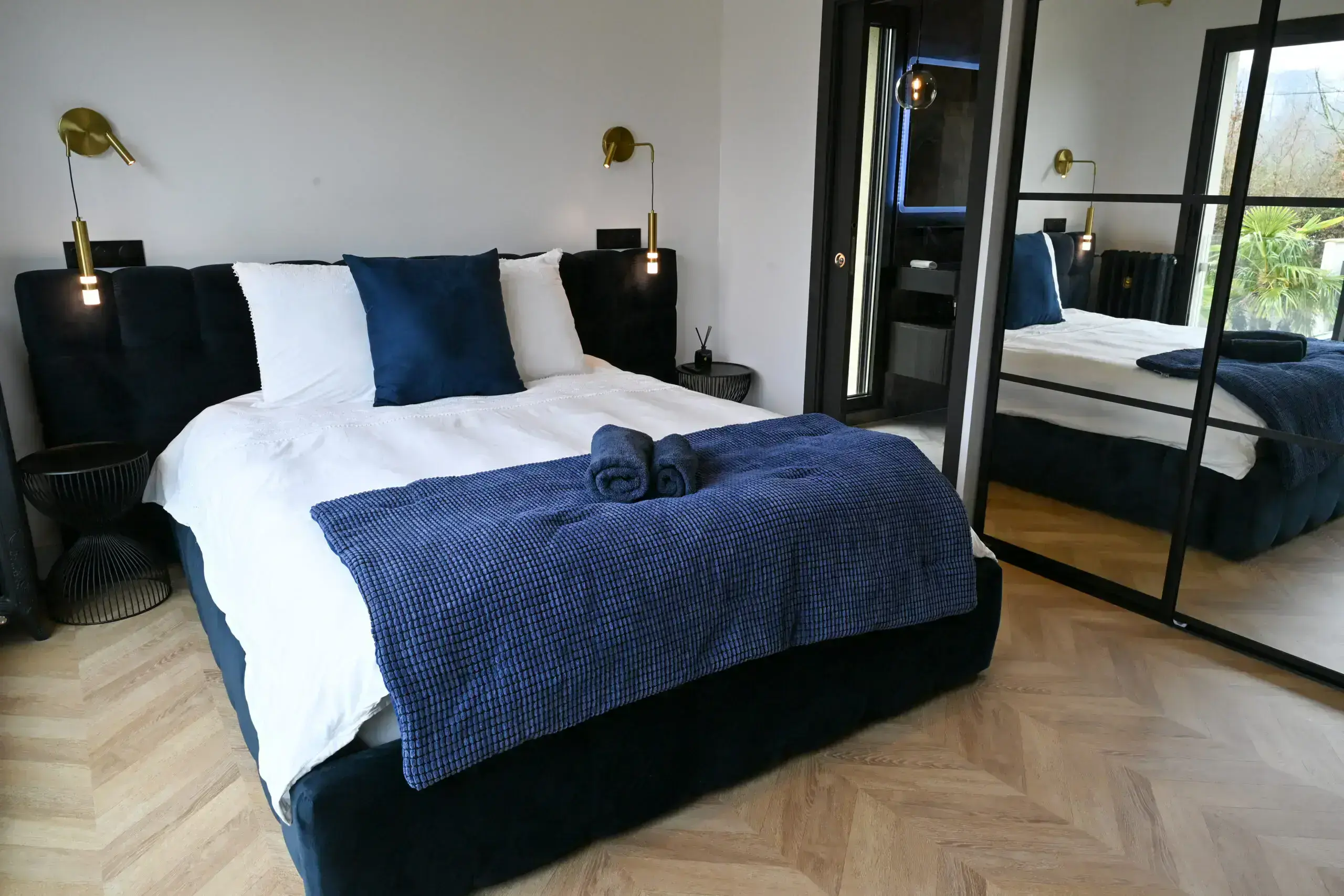 Chambre 3 Chambre parentale lumineuse ouvrant sur une terrasse avec palmiers, décoration bleue et or.
