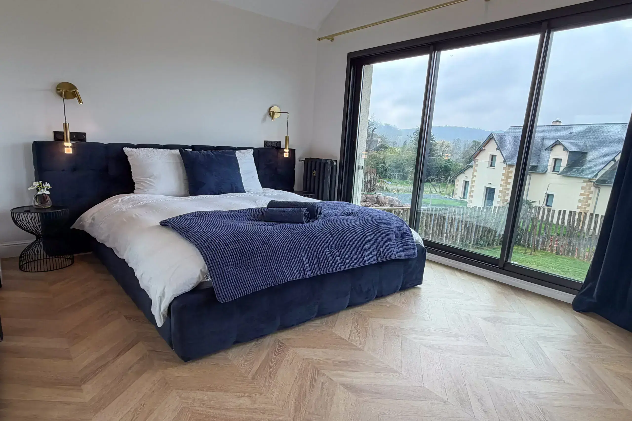 Chambre 2 Chambre élégante avec lit king size en velours bleu, parquet en chêne et dressing miroir.