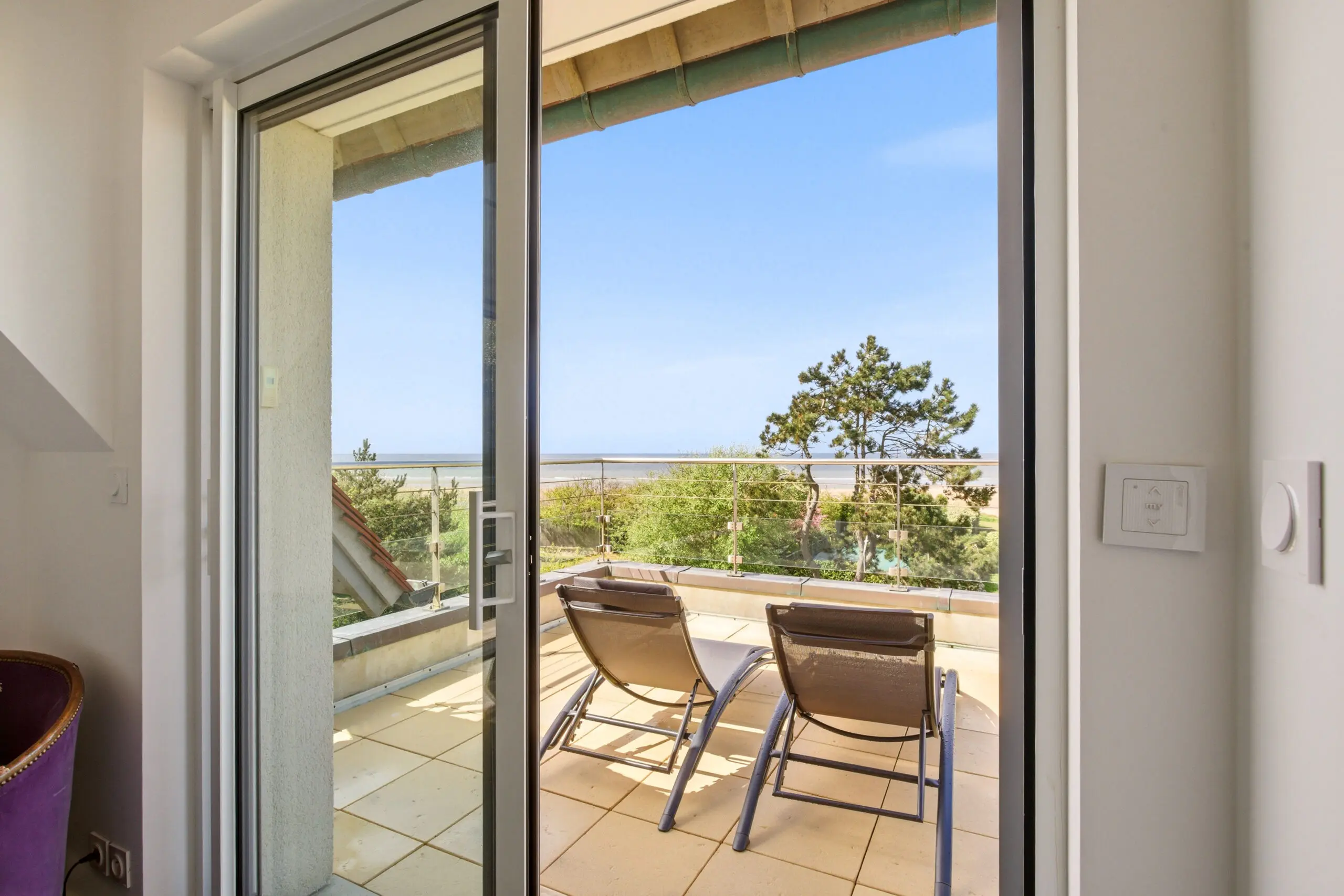 Vue terrasse avec chaises longues et panorama sur la plage de Deauville depuis l'appartement de luxe «56» — conciergerie all‑inclusive, confort & sérénité.